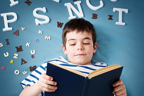 Dreng med bog og bogstaver 1. klasse