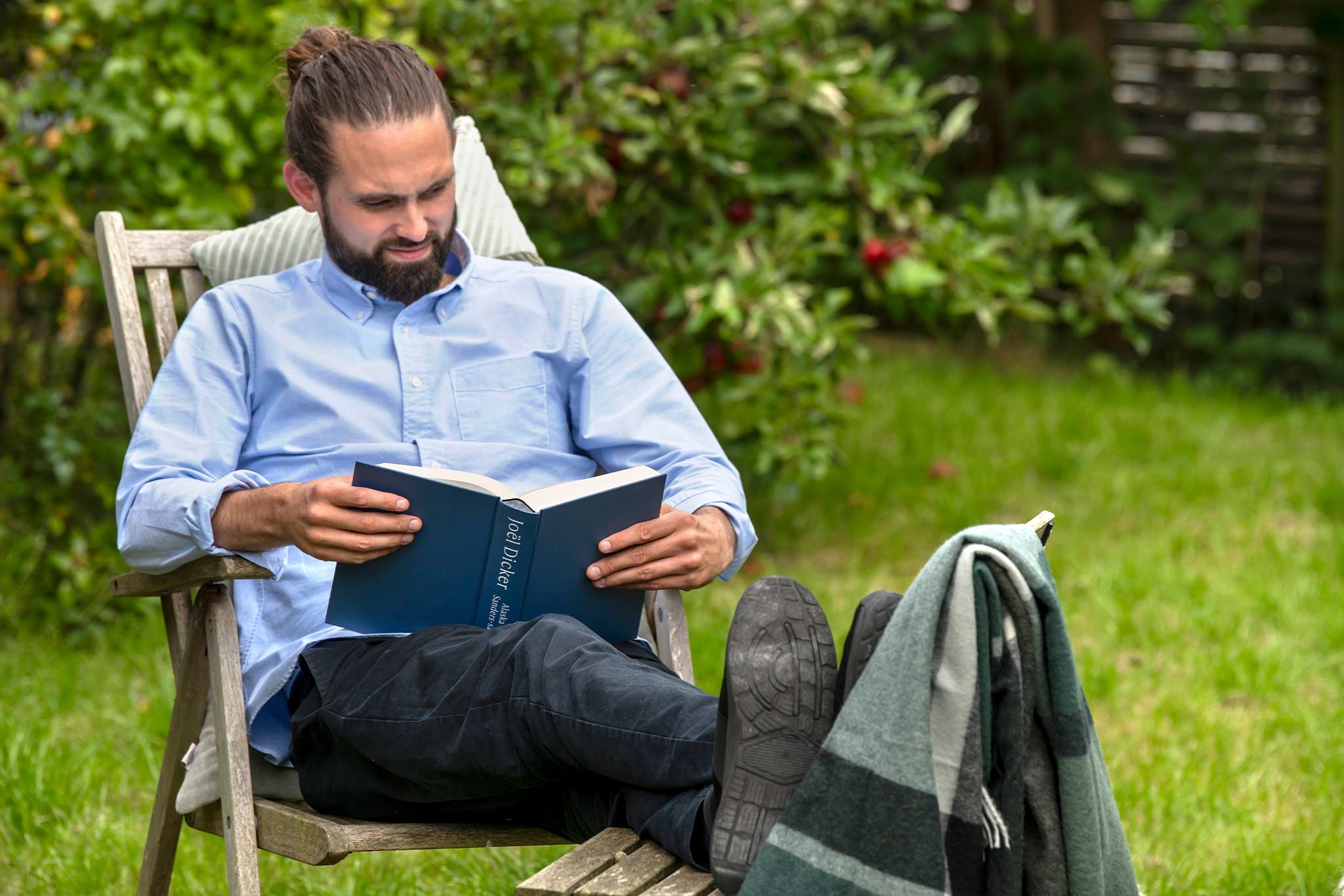Mand læser bog udenfor