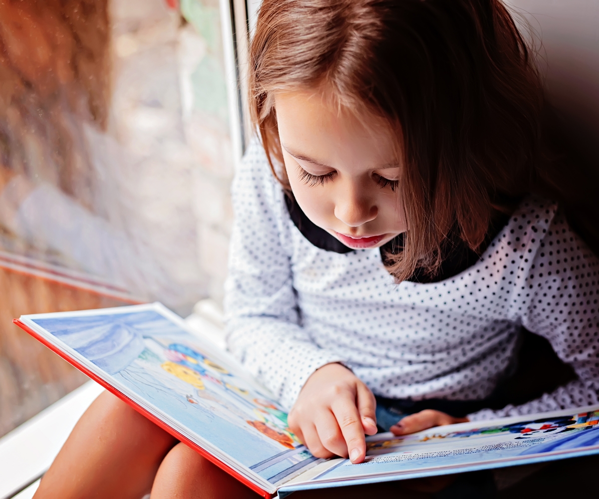 Pige læser bog selv og øver læsning